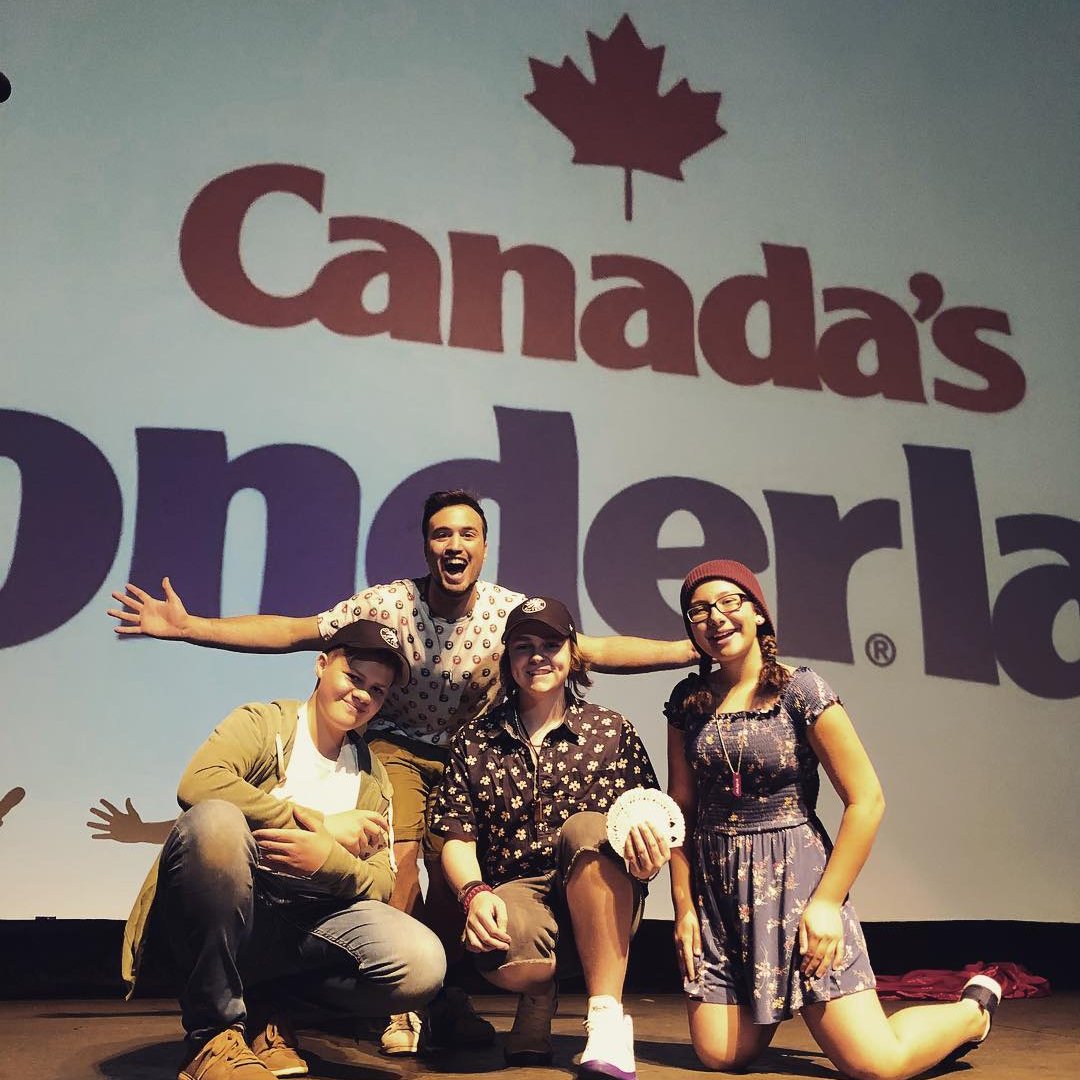 Aaron Matthews and his team pose excitedly on stage at Canada’s Wonderland after a thrilling magic performance. With big smiles and dynamic energy, they celebrate their show in front of the iconic park’s backdrop.