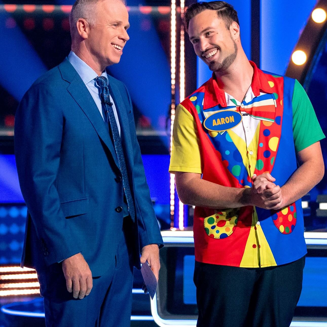 Aaron is happy while performing on stage, enjoying his moment on Family Feud Canada with host Gerry Dee.